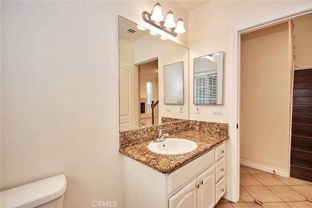 bathroom with tile patterned flooring, vanity, and toilet