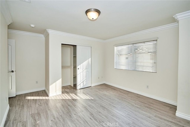 unfurnished bedroom featuring light wood-type flooring, a closet, and ornamental molding