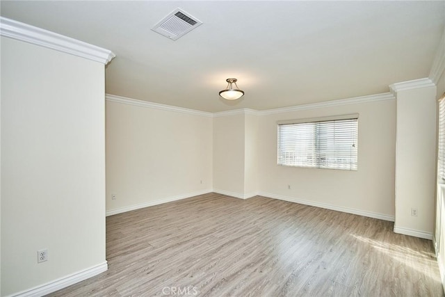 empty room with light hardwood / wood-style flooring and ornamental molding