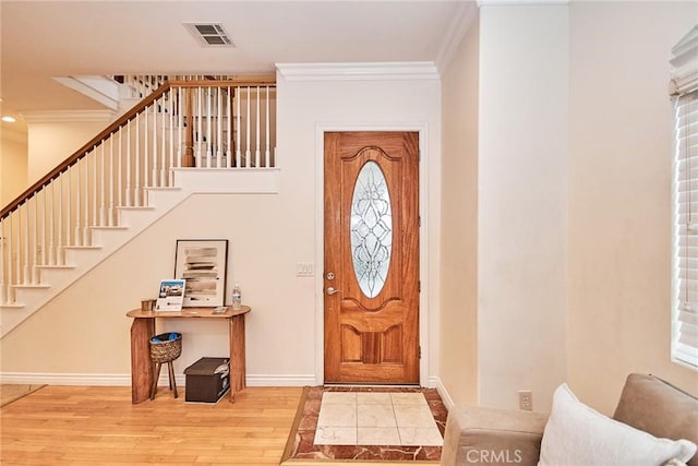 entrance foyer featuring ornamental molding and light hardwood / wood-style flooring