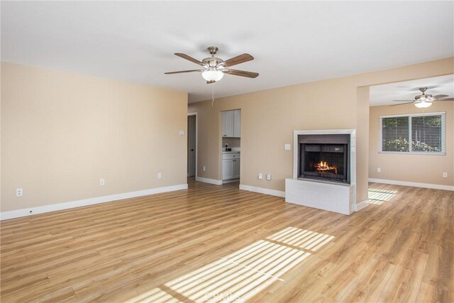 unfurnished living room featuring light wood-type flooring and ceiling fan