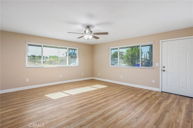 empty room with ceiling fan, light hardwood / wood-style flooring, and a healthy amount of sunlight