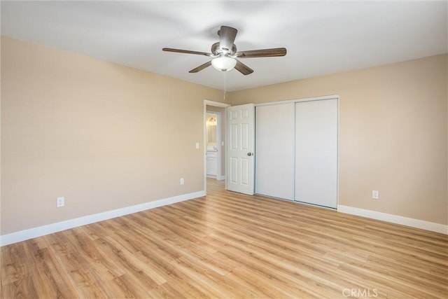 unfurnished bedroom featuring ceiling fan, a closet, and light wood-type flooring