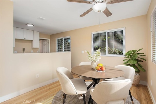 dining space featuring light hardwood / wood-style floors, sink, and ceiling fan