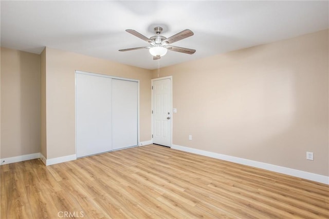 unfurnished bedroom featuring ceiling fan, light hardwood / wood-style floors, and a closet