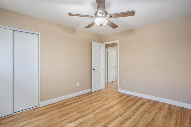 unfurnished bedroom with ceiling fan, a closet, and light hardwood / wood-style floors