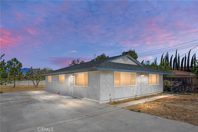 property exterior at dusk with a patio area