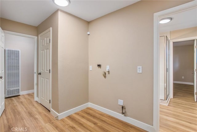 laundry area with light wood-type flooring