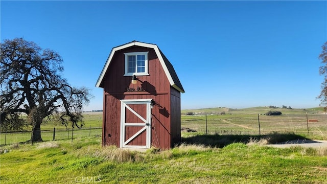 view of outbuilding featuring a rural view and a yard