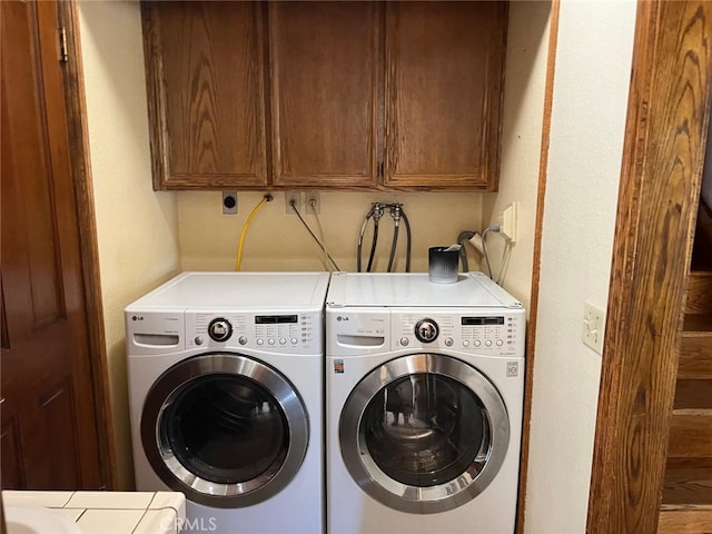 clothes washing area featuring cabinet space and washing machine and clothes dryer