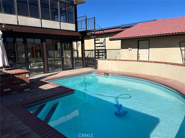 outdoor pool featuring stairs and a patio