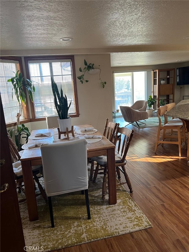 dining area featuring a textured ceiling and wood finished floors