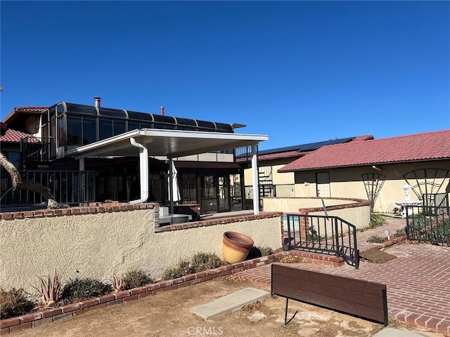 back of property with a patio area, a tiled roof, and stucco siding