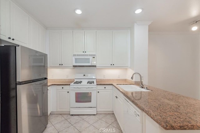 kitchen with sink, light tile patterned floors, white appliances, light stone countertops, and white cabinets