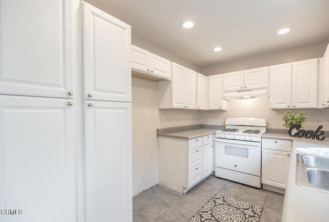 kitchen with light tile patterned floors, sink, white cabinetry, and white range with gas cooktop