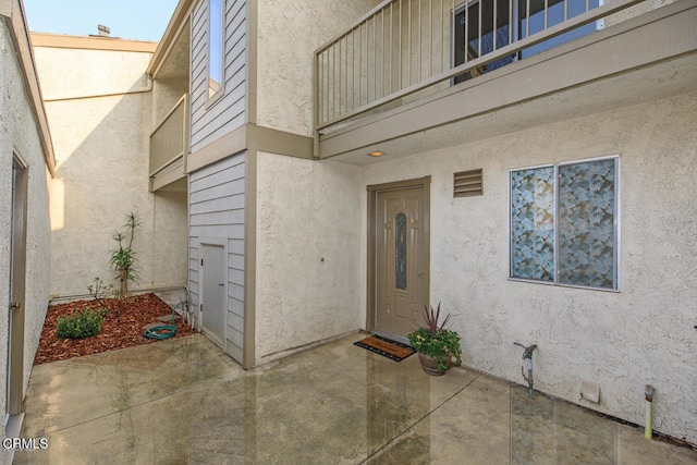 entrance to property with a balcony and a patio