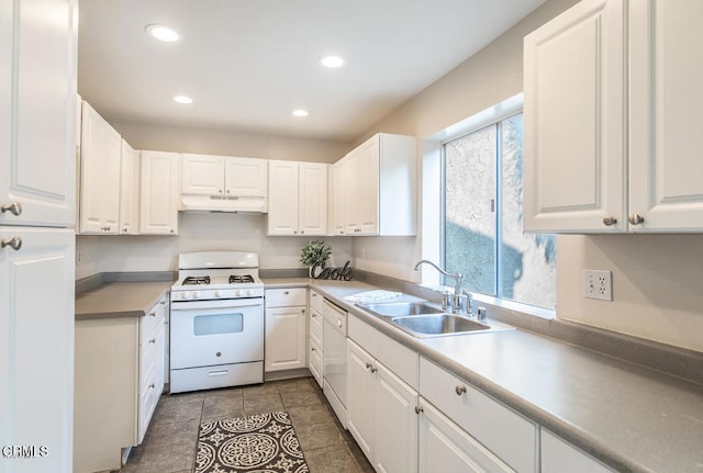 kitchen featuring sink, white appliances, white cabinets, and dark tile patterned floors