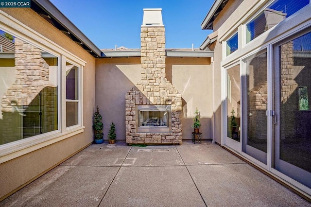 view of patio with an outdoor stone fireplace