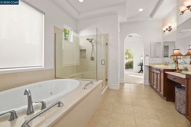 bathroom with plus walk in shower, tile patterned flooring, a raised ceiling, and vanity