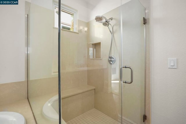 bathroom with a shower with door