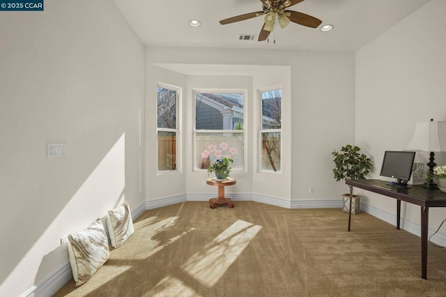 carpeted office space with ceiling fan