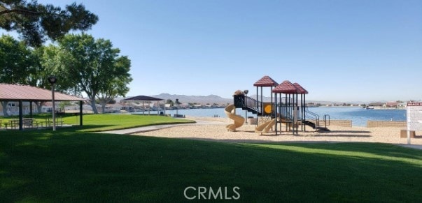 view of jungle gym featuring a lawn and a water view