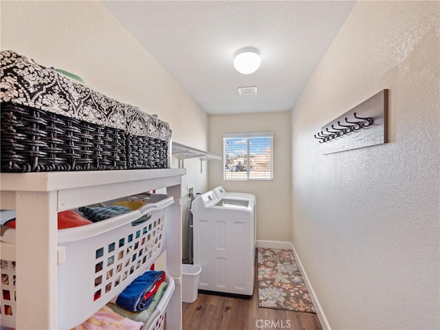 clothes washing area with washer and dryer and wood-type flooring