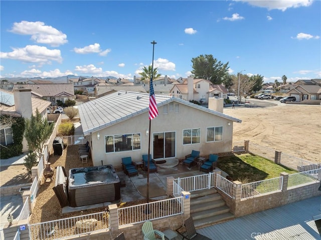 back of house with a patio area and a hot tub