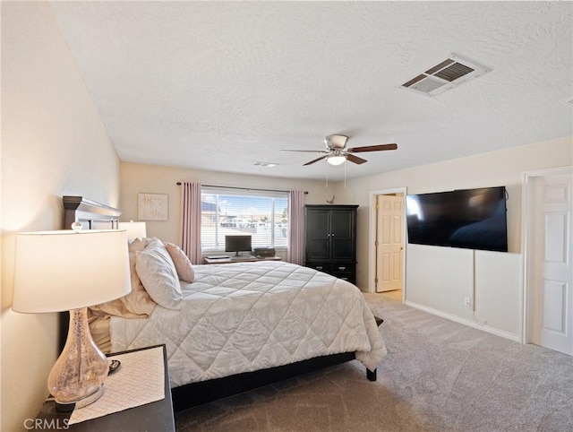 carpeted bedroom featuring a textured ceiling and ceiling fan