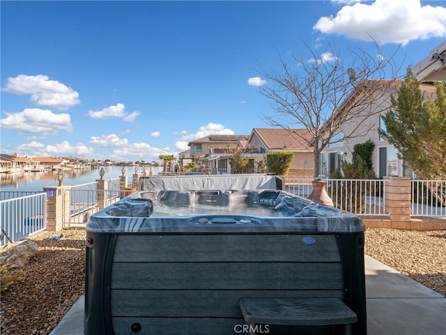 exterior space with a water view and a hot tub