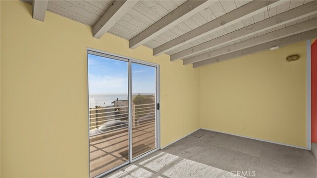 carpeted spare room featuring a water view, beam ceiling, and wooden ceiling