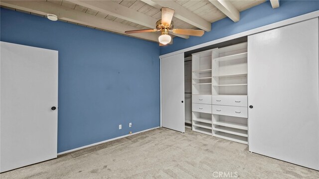 unfurnished bedroom with ceiling fan, wood ceiling, light colored carpet, and beamed ceiling