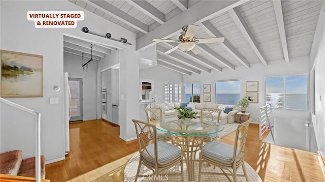 dining area with ceiling fan, lofted ceiling with beams, and hardwood / wood-style floors