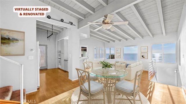 dining room featuring hardwood / wood-style floors, vaulted ceiling with beams, a wealth of natural light, and ceiling fan