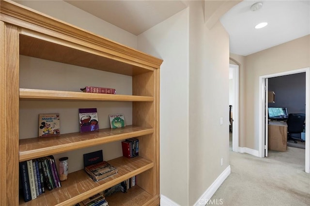 hallway featuring light colored carpet