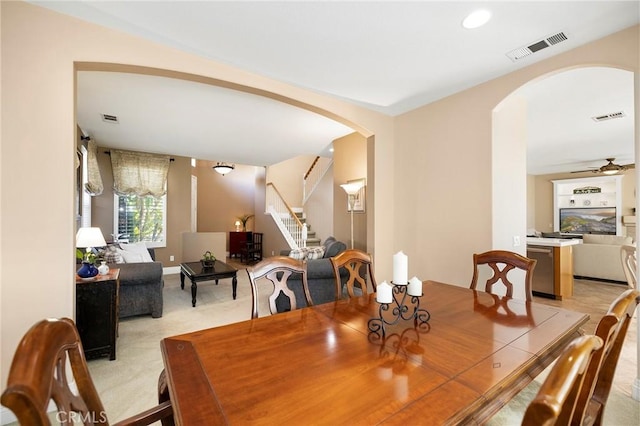 dining room with ceiling fan and light carpet