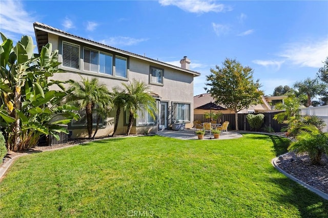 back of property featuring a lawn and a patio area