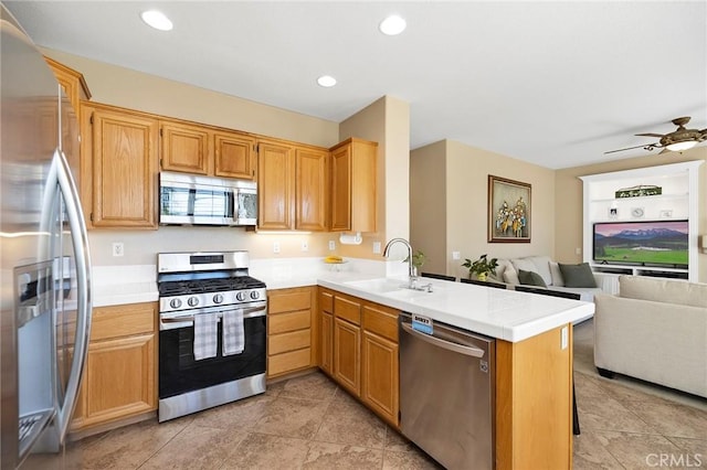 kitchen with ceiling fan, sink, kitchen peninsula, and stainless steel appliances