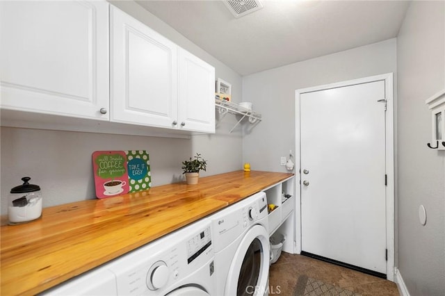 clothes washing area with cabinets and washing machine and clothes dryer