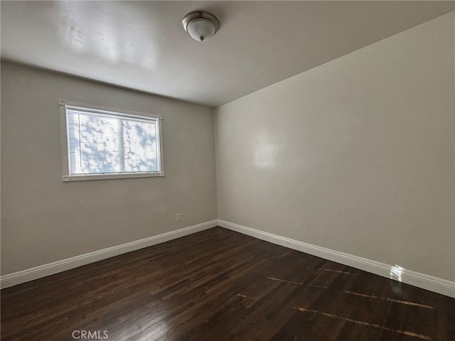 spare room with dark hardwood / wood-style flooring