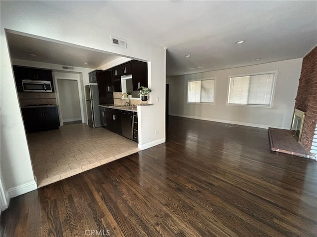 unfurnished living room with dark hardwood / wood-style flooring and sink