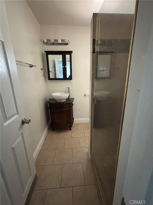 bathroom with tile patterned flooring, vanity, and a shower with door