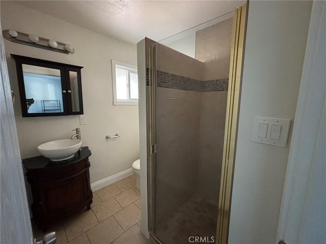 bathroom with vanity, toilet, tile patterned floors, and walk in shower