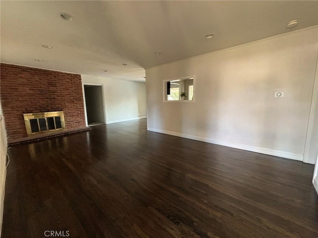 unfurnished living room with a brick fireplace and dark hardwood / wood-style floors