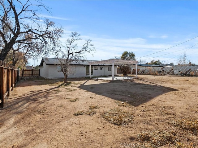 back of property with a pergola and a patio area