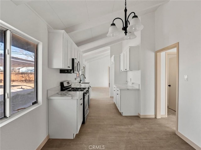 kitchen featuring appliances with stainless steel finishes, white cabinetry, an inviting chandelier, hanging light fixtures, and lofted ceiling with beams