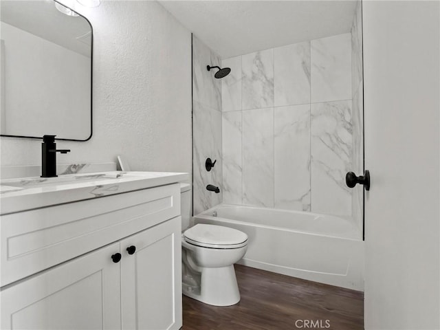 full bathroom with toilet, tiled shower / bath combo, vanity, and hardwood / wood-style flooring