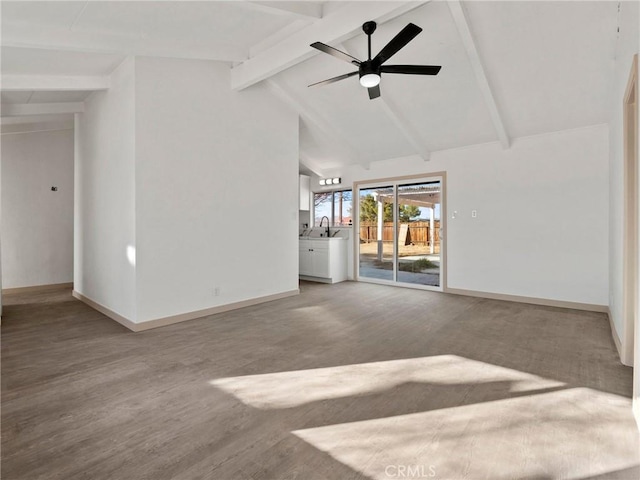 unfurnished living room featuring ceiling fan, wood-type flooring, vaulted ceiling with beams, and sink