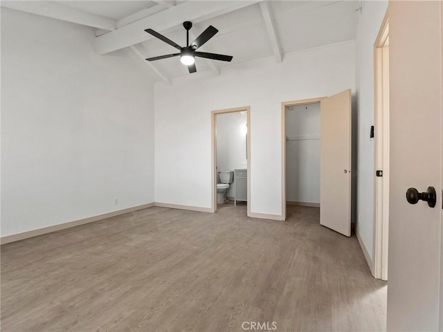 unfurnished bedroom with ensuite bath, vaulted ceiling with beams, ceiling fan, and light hardwood / wood-style flooring