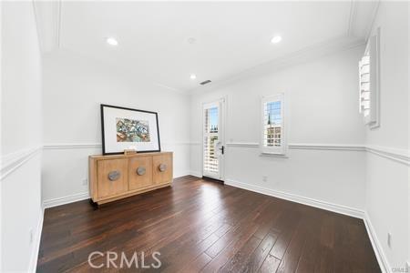 spare room featuring dark hardwood / wood-style flooring and crown molding